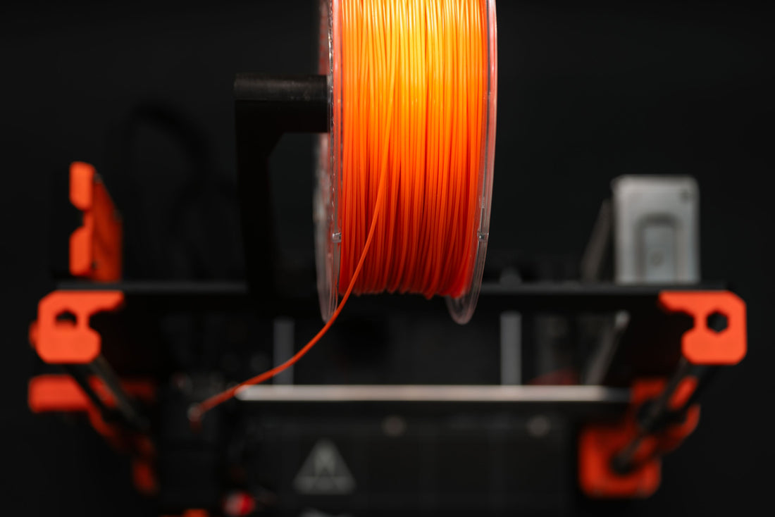 Close-up of an orange 3D printer filament spool